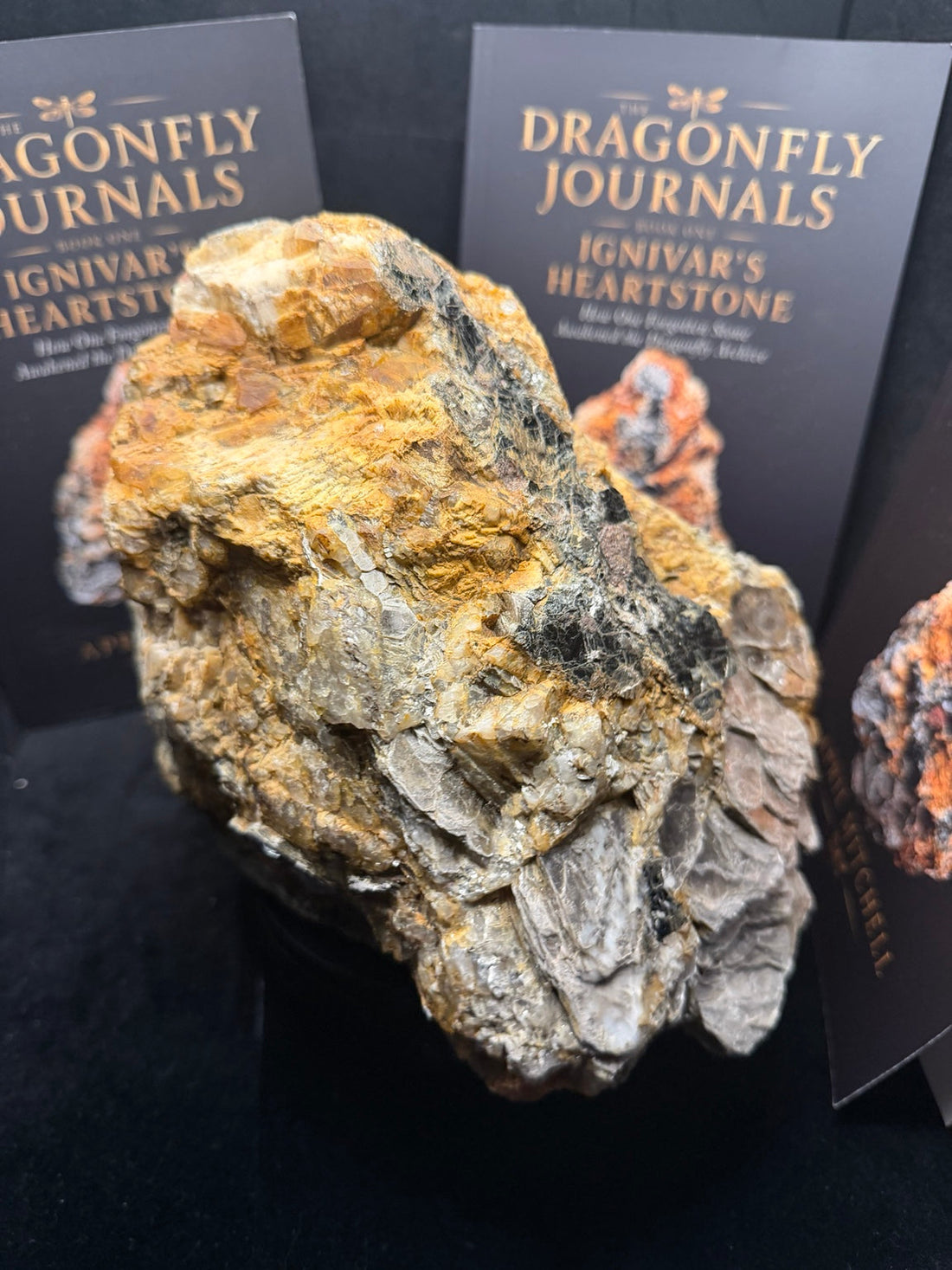 The real Heartstone displayed in front of The Dragonfly Journals books by April Louann Mitchell